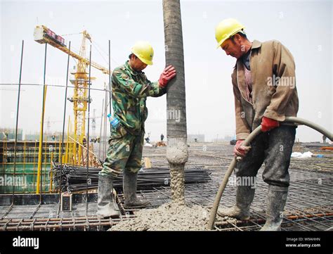 Chinese workers pour concrete on the construction site of the main ...