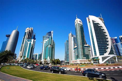 cars are driving on the road in front of tall buildings and skyscrapers ...