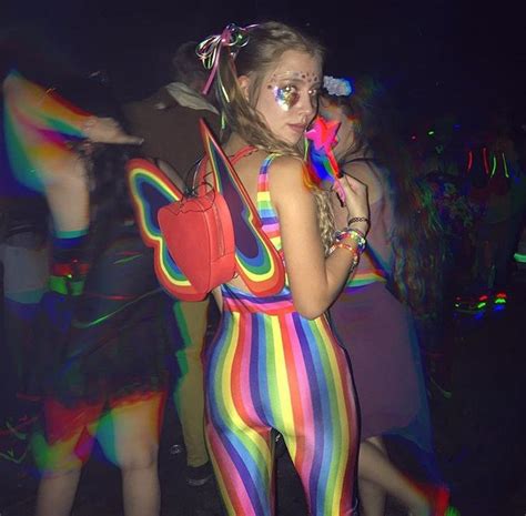 a group of people standing around each other at a party with colorful ...