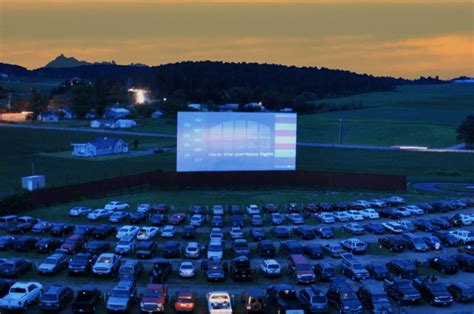 an aerial view of a parking lot with cars parked in front of it at dusk