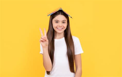 Menina adolescente feliz segura livro mostrando paz na escola de fundo ...