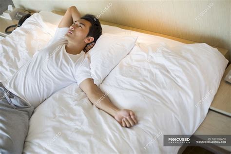 Chinese man lying on bed and looking up — comfortable, lifestyle ...