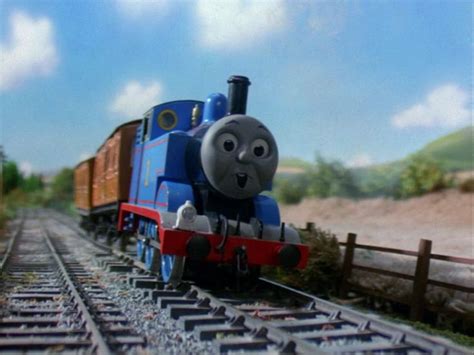 a thomas the tank engine is coming down the tracks with his eyes open ...