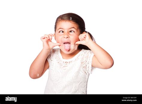 Cute girl making funny face sticking tongue out and crossed eyes ...