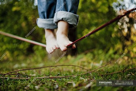 Man walking on tightrope — barefoot, green color - Stock Photo | #154361556