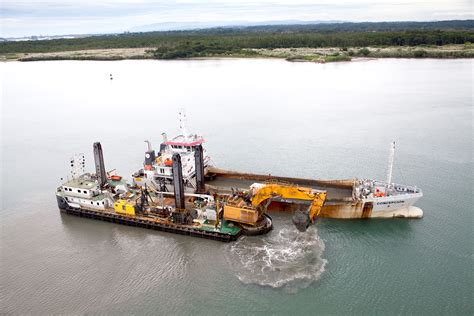 Split-hull hopper dredgers discharge their loads from underneath the ...