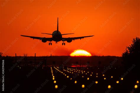 Plane Landing At Sunset