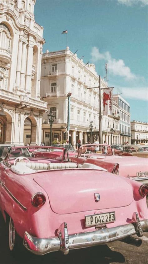 Download A Pink Car Parked In Front Of A Building Wallpaper ...