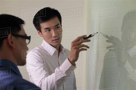 Man explaining something on white board. - Stock Photo - Dissolve