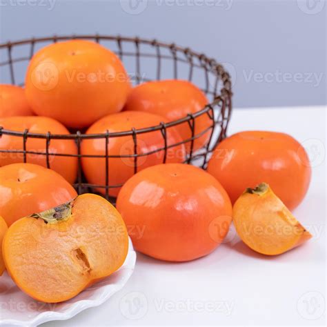 Fresh beautiful sliced sweet persimmon kaki isolated on white kitchen ...