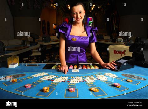 Smiling dealer, croupier showing cards in casino at blackjack table ...