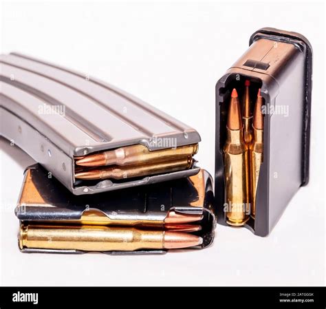 Three different caliber and size loaded rifle magazines on a white ...