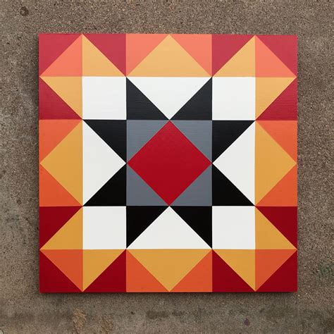 an orange, black, and red geometrical painting on concrete with cement ...