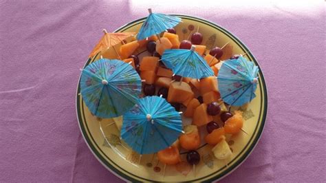 a plate full of fruit with blue umbrellas on it