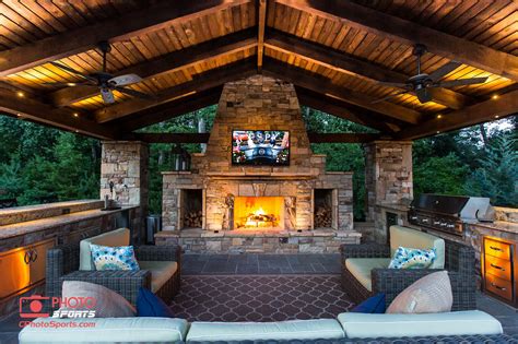 A pavilion with an outdoor kitchen, fireplace and an entertainment ...