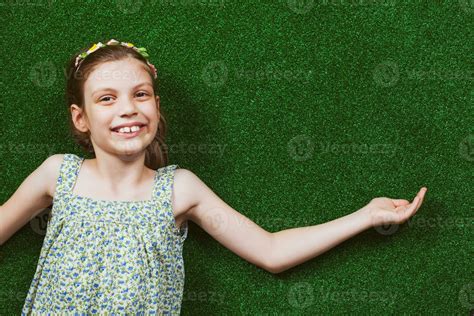 Little girl is lying on artificial grass 23950768 Stock Photo at Vecteezy