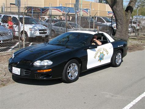 a police car parked in front of a fence