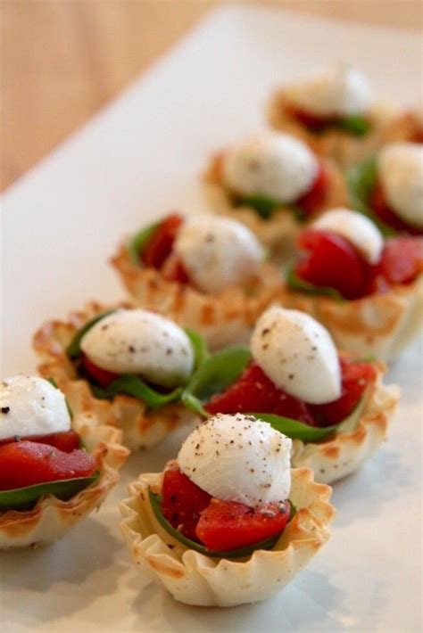 tartlets stuffed with chopped tomato, fresh basil leaves, and ...