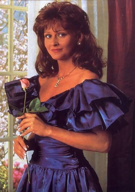 a woman in a blue dress holding a rose