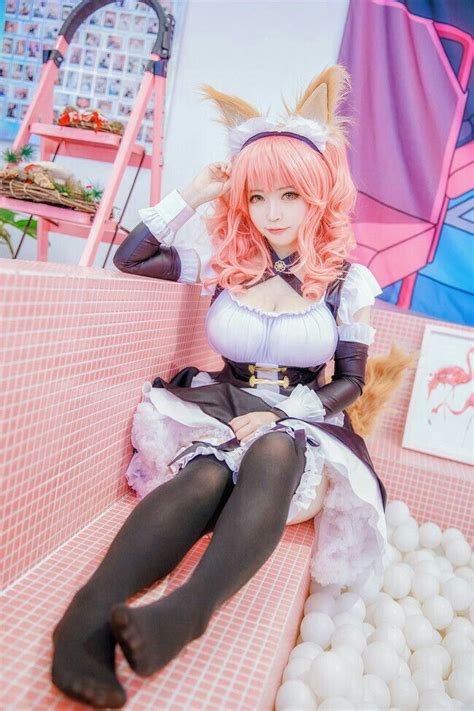 a woman sitting on top of a pink bench next to white balls and an umbrella