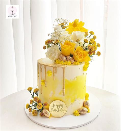 there is a yellow and white cake with flowers on it