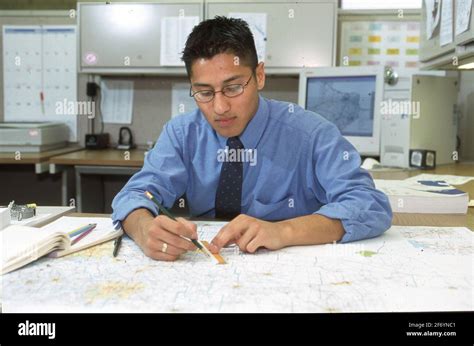 Austin, Texas USA, 2002: Young Hispanic man using maps in his job as a ...