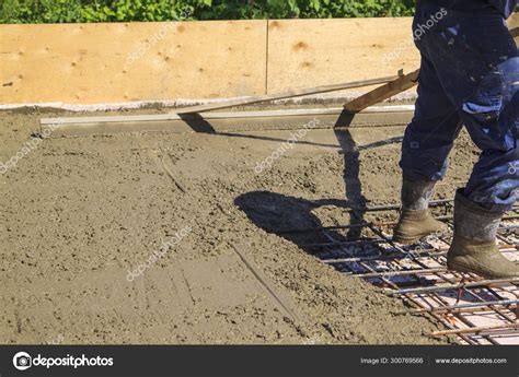 Worker leveling fresh concrete slab with a special working tool Stock ...