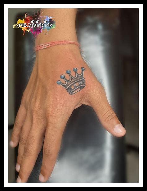 a hand with a crown tattoo on it