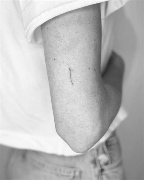 Minimalist line tattoo on the tricep.