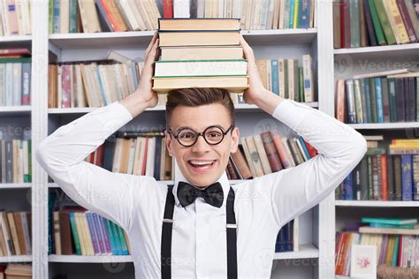 He loves studying. Cheerful young man in shirt and bow tie sitting at ...