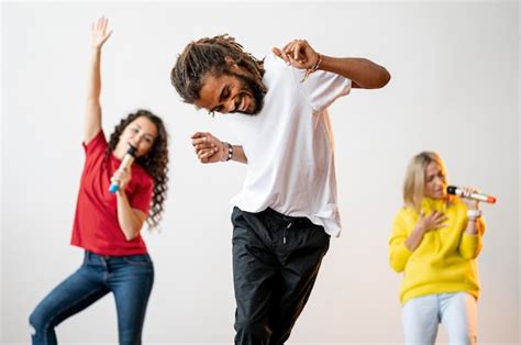 Pessoas multirraciais de tiro médio, cantando e dançando | Foto Grátis