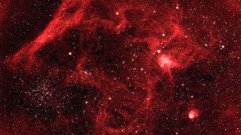 Download A Red Nebula With Stars In It | Wallpapers.com