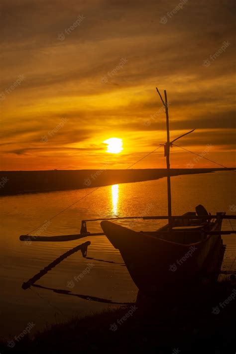 Premium Photo | Beautiful calm sunset at river with silhouette of a boat