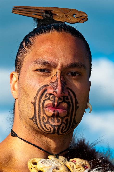 A Maori warrior with a ta moko (facial tattoo) performs a war haka ...