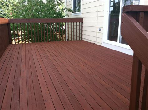 a wooden deck with railings next to a house