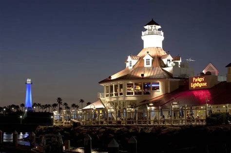 the lighthouse is lit up at night by the water