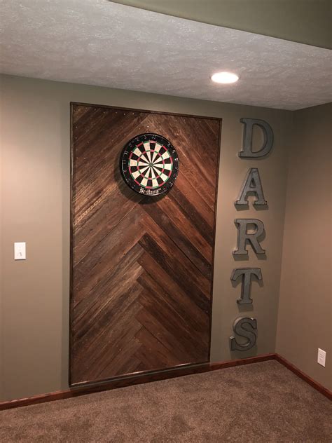 a dart sign mounted to the side of a wall next to a darts door