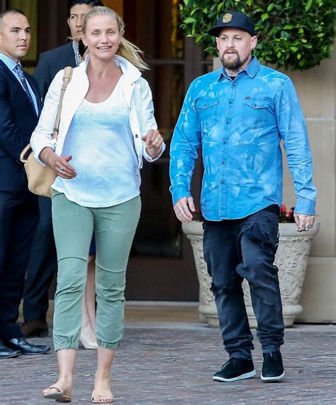 a man and woman are walking down the street together, holding hands ...