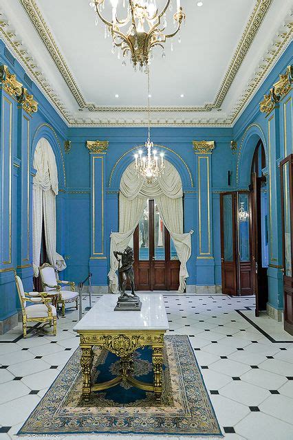 an ornately decorated room with blue walls and gold trim, chandelier ...