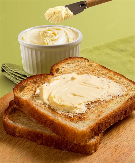 Premium Photo | Toasted bread slices and butter on wooden table