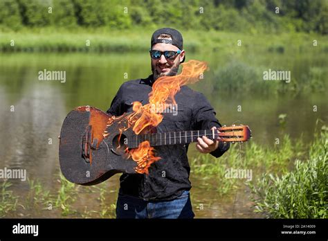 The guy set fire to the guitar and tries to play it. The young musician ...