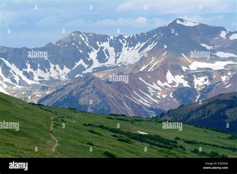 Snow capped mountains with hikers on a trail Stock Photo - Alamy