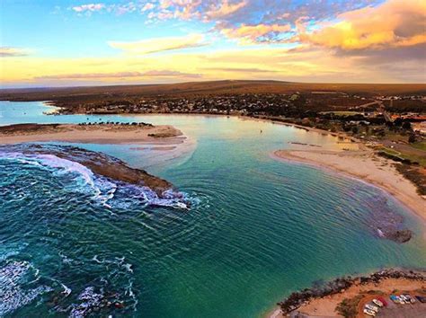 an aerial view of the beach and ocean at sunset or sunrise with ...