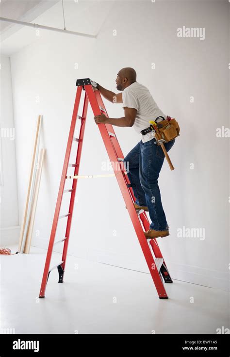 African American construction worker climbing ladder Stock Photo - Alamy