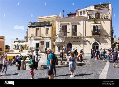 Tourists by the fountain in the Piazza Duomo, Taormina, Sicily, Italy ...