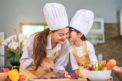 Little Boy Kisses Mom While Cooking At Home Photo Background And ...