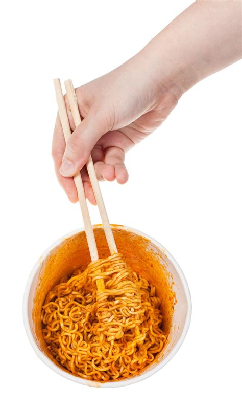 Premium Photo | Hand keeps chopsticks in cooked instant noodles