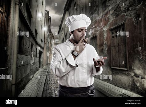 Chef with cognac and cigar smoking in dark street Stock Photo - Alamy