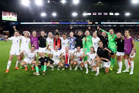 a group of women's soccer players pose for a team photo on the field