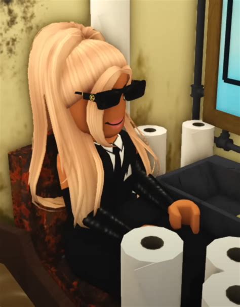 a woman sitting at a desk with two rolls of toilet paper in front of her